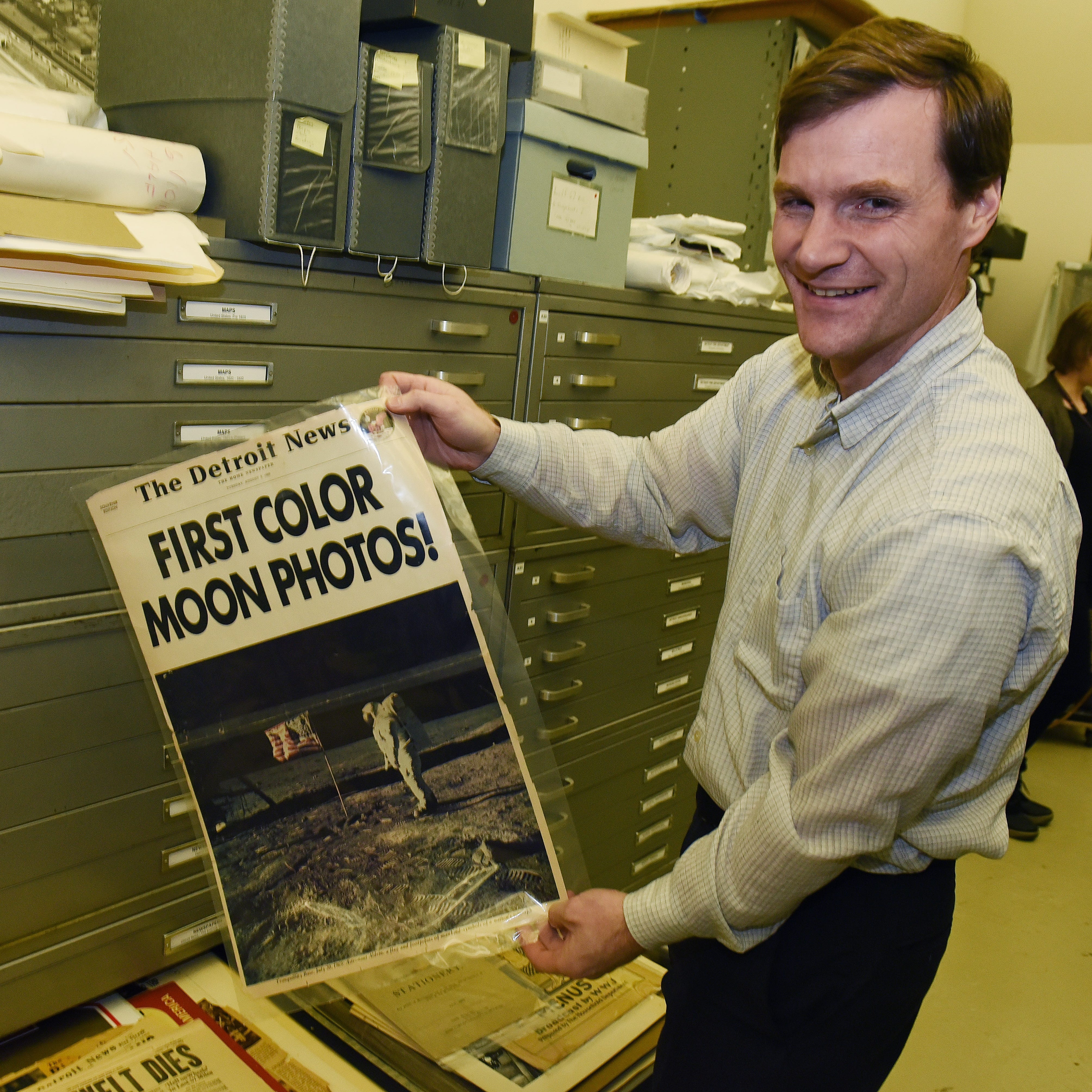 Jeremy Dimick, Director of Collections for the Detroit Historical Society , holds an August 5, 1969 front page of the Detroit News celebrating the first photos taken on the moon.