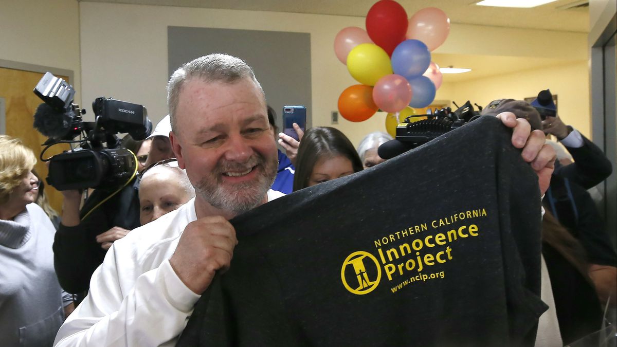 Ricky Davis holds up a Northern California Innocence Project T-shirt Thursday, Feb. 13, 2020, upon being released from prison after serving nearly 15 years for a murder he did not commit. A new suspect, Michael Green, right, has been charged with murder in the July 1985 stabbing death of newspaper columnist Jane Hylton, 54, in El Dorado Hills, Calif.