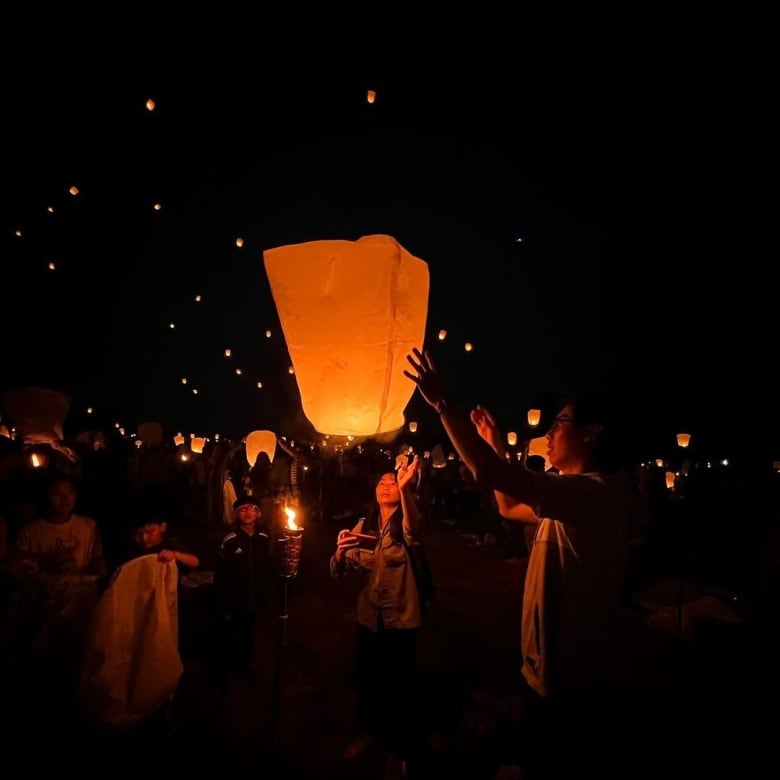 A person releasing a lantern into the sky.